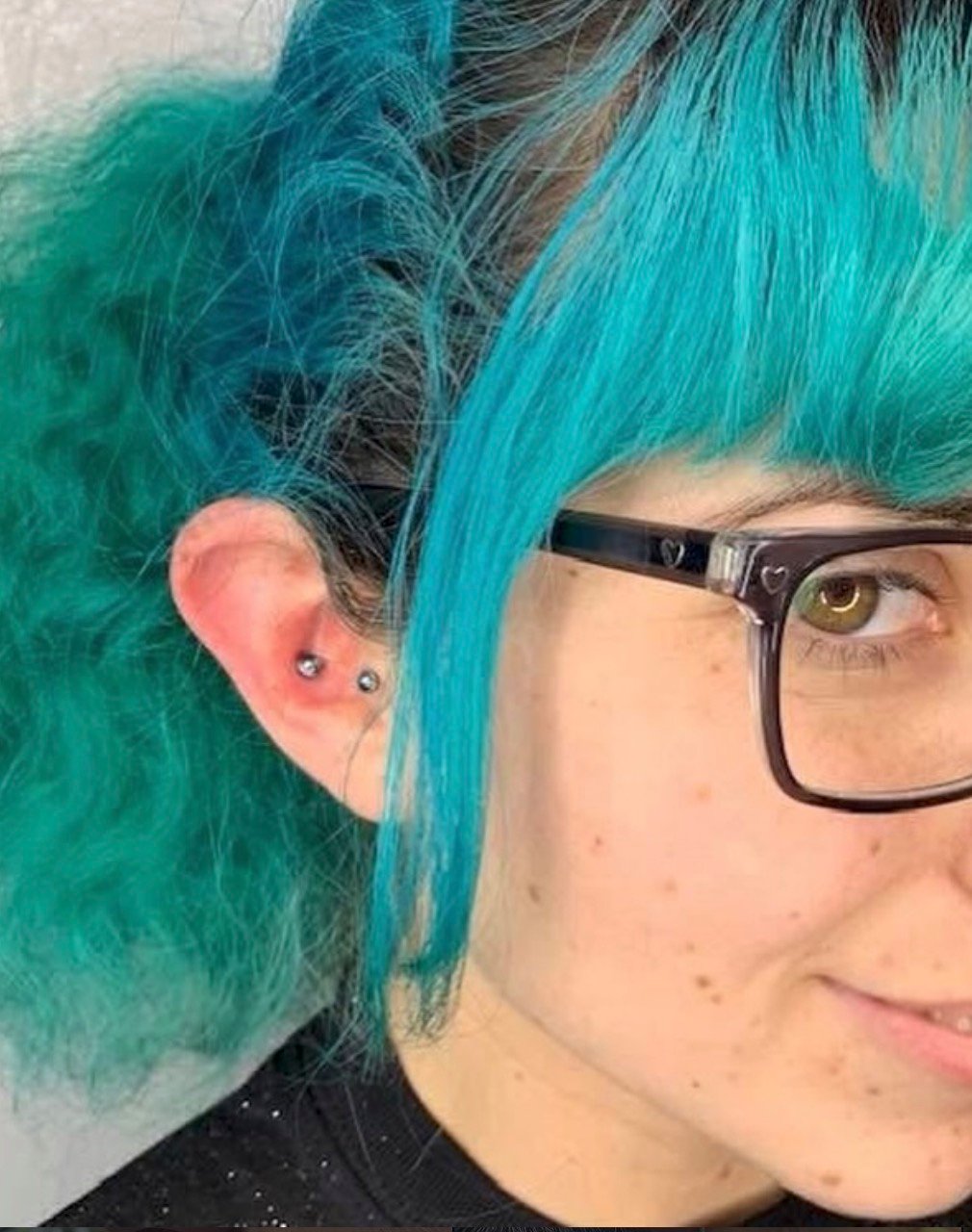 Healed ear piercings with gold jewelry at our San Diego piercing studio